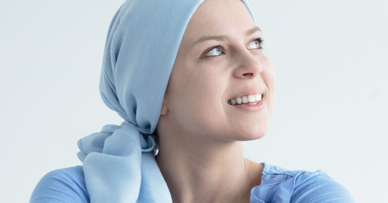 Foto einer lächelnden Frau mit blauem Kopftuch